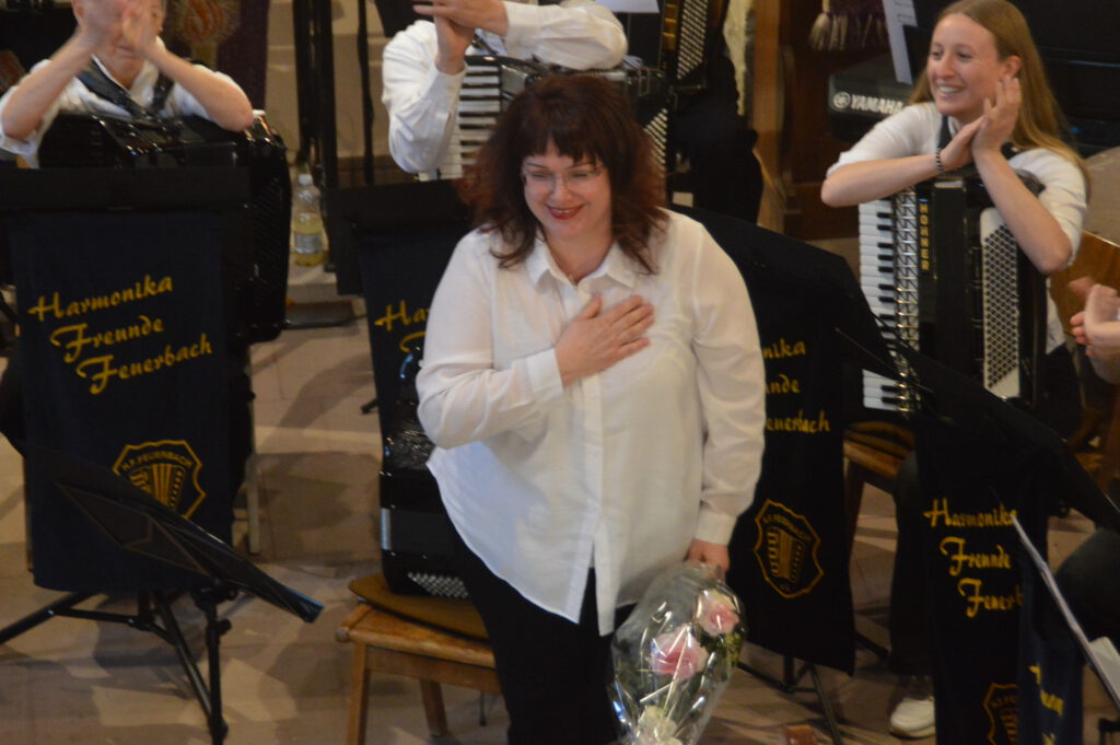 Maryna Obodovska verneigt sich vor dem Publikum, einen Blumenstrauß in der Hand.